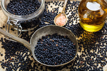 Black lentils on an old metallic spoonの写真素材