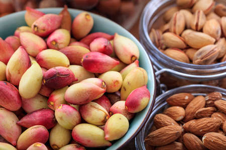 Fresh pistachios in shell in a ceramic potの写真素材