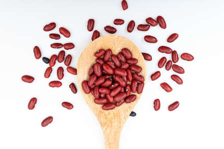 Raw red beans in a wooden spoon on white background