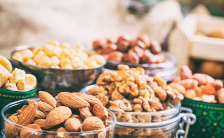 Almonds, peanuts and walnuts in bowlsの写真素材