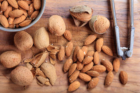 Almonds and a nutcracker on a wooden table