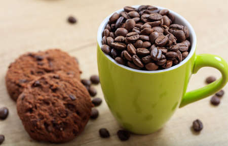 Cup with coffee beans and cookiesの写真素材