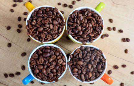 Colorful cups full of coffee beansの写真素材