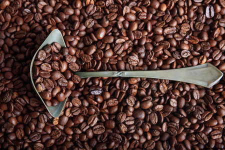Coffee beans background and a metal old spoonの写真素材