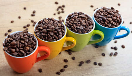 Colorful cups full of coffee beansの写真素材