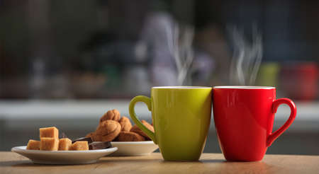 Cups of coffee and cookies on an office tableの写真素材