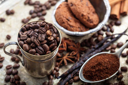Metal cup with coffee beans and a spoon with coffeeの写真素材