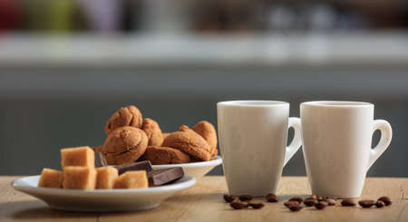 Cups of coffee and cookies on an office tableの写真素材