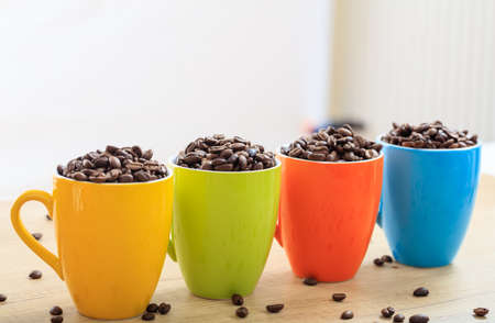 Colorful cups full of coffee beansの写真素材