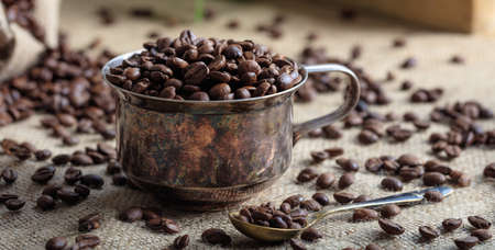 Coffee beans and an old cup on a burlapの写真素材