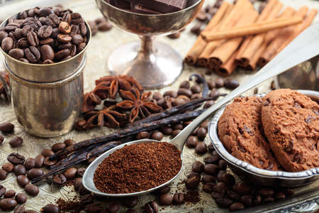 Metal cup with coffee beans and a spoon with coffeeの写真素材