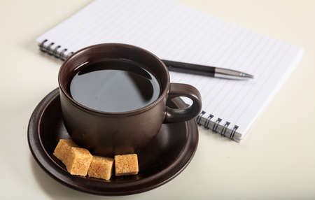 Cup of coffee and a notepad on an office tableの写真素材