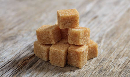 Brown sugar cubes on a wooden tableの写真素材