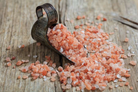 Pink Himalayan salt crystals and a metal scoop