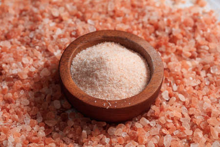 Wooden bowl on pink Himalayan salt backgroundの写真素材