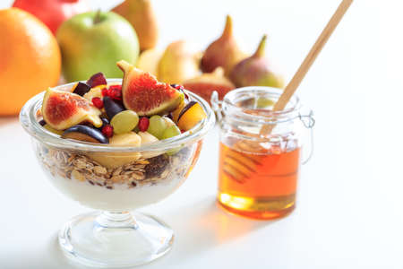 Yogurt, muesli and fresh fruits in a bowl on white backgroundの写真素材