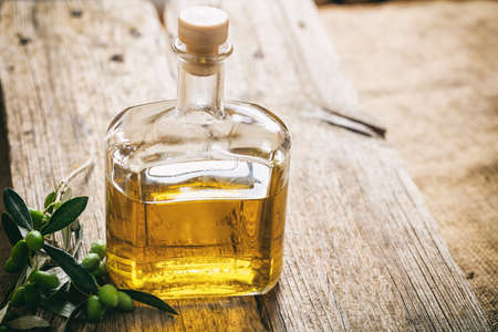 Bottle of olive oil on a wooden tableの写真素材