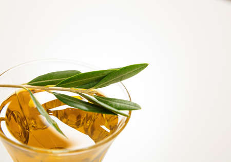 Olive oil and olive twig on white backgroundの写真素材