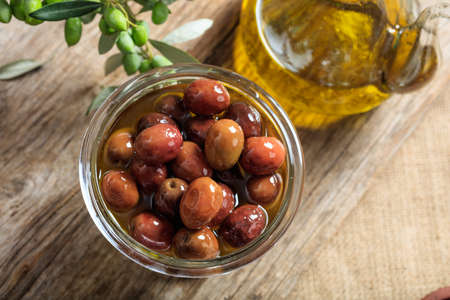 Olives and olive oil on a wooden tableの写真素材