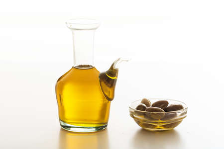Bottle of olive oil and olives on white backgroundの写真素材