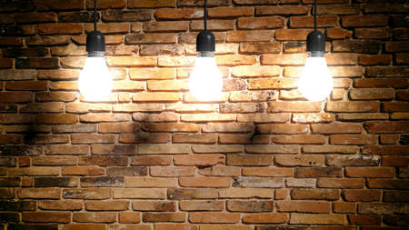 3d rendering light bulbs hanging on brick wall backgroundの写真素材