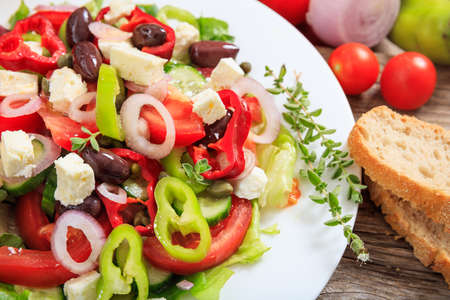 Fresh greek salad on wooden backgroundの写真素材