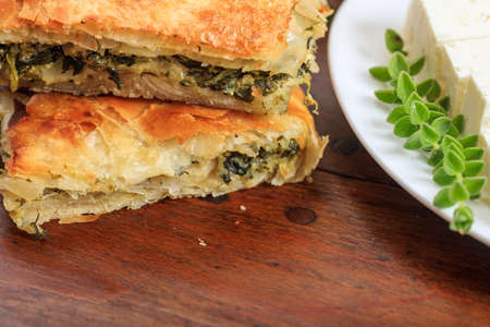 Spinach pie pieces on a wooden surfaceの写真素材
