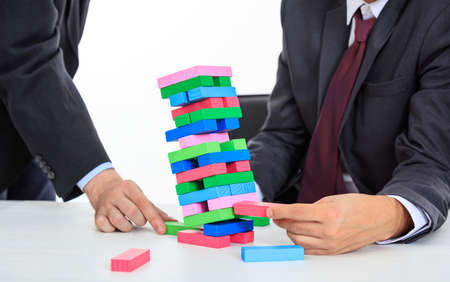 Businessmen playing colorful wooden blocks gameの写真素材