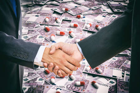 Formal handshake on pills and banknotes backgroundの写真素材