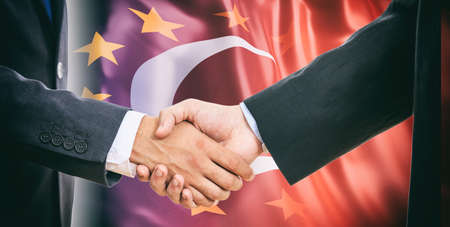Formal handshake on EU - Turkey flags backgroundの写真素材