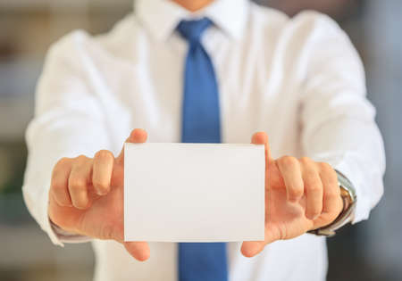Businessman holding a white cardの写真素材