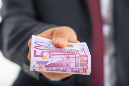 Man in suit offering moneyの写真素材