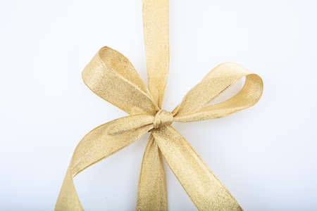 Golden ribbon and bow on white backgroundの写真素材