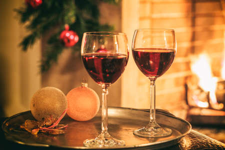 Two glasses of red wine near a fireplaceの写真素材