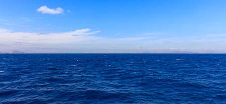 Blue sky with clouds and sea backgroundの写真素材
