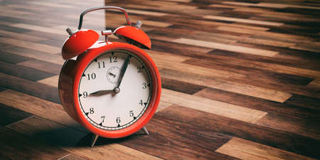 3d rendering red alarm clock on wooden floor backgroundの写真素材