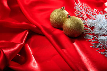 Golden christmas balls on red satinの写真素材