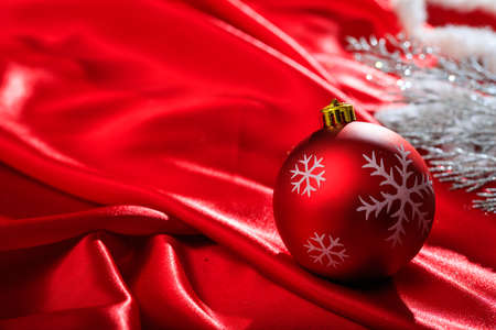 Red christmas ball on red satinの写真素材