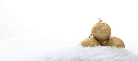 Golden christmas ball and snow on white backgroundの写真素材
