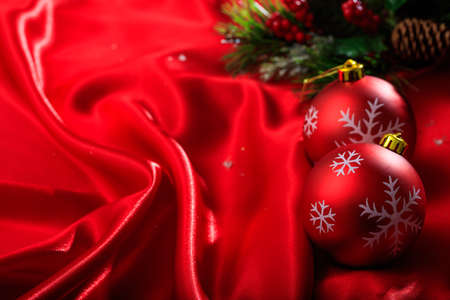 Red christmas balls on red satinの写真素材