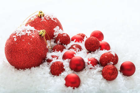 Red christmas balls and snow on white backgroundの写真素材