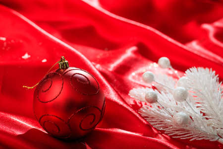 Red christmas ball on red satinの写真素材