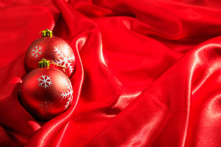 Red christmas balls on red satinの写真素材