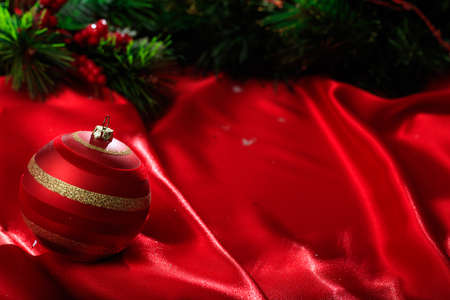 Red christmas ball on red satinの写真素材