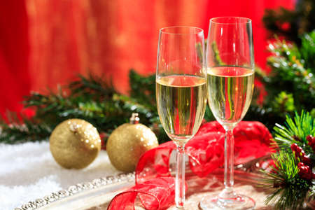 Champagne glasses and christmas balls on snowの写真素材