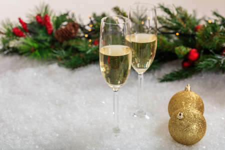 Champagne glasses and christmas balls on snowの写真素材