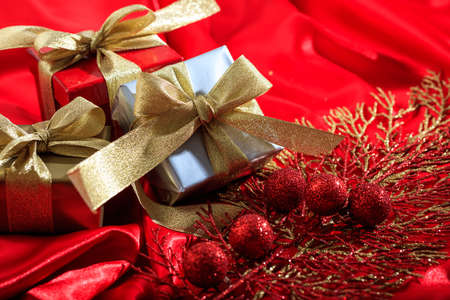 Gift boxes and ornaments on a red satin backgroundの写真素材