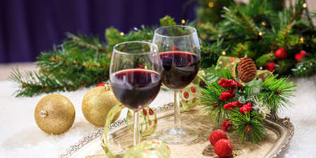 Red wine glasses and christmas balls on snowの写真素材