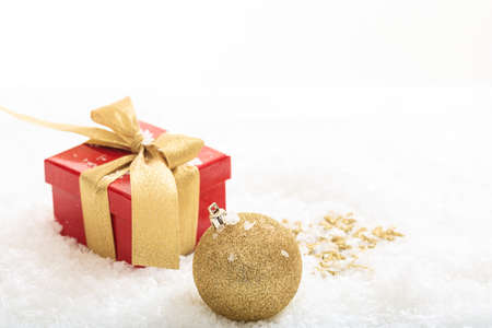 Red gift box and ball on snowの写真素材