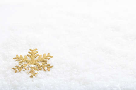 Golden snow flake on snow backgroundの写真素材